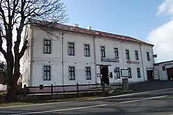 Bílá dvoupatrová budova s červenou střechou