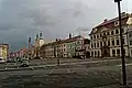 Jižní fronta domů s biskupskou rezidencí (zcela vpravo), domem U Špuláků (sousední růžová fasáda) a kostelem Nanebevzetí P. Marie v pozadí