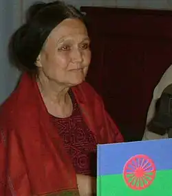 Milena Hübschmannová během veřejné besedy 30. června 2004. V pravém dolním rohu romská vlajka.