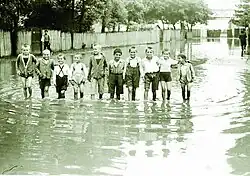 Děti si hrají na zaplavené ulici, 1930-1940