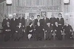 Členové šesté vlády Davida Ben Guriona. Sedící zleva doprava: Levi Eškol, Jisra'el Bar Jehuda, Golda Meirová, Jicchak Ben Cvi, David Ben Gurion, Pinchas Rosen a Perec Naftali. Stojící zleva doprava: Mordechaj Namir, Zalman Aran, Pinchas Sapir, Bechor-Šalom Šitrit, Kadiš Luz, Jisra'el Barzilaj, Josef Burg, Mordechaj Bentov a Moše Karmel