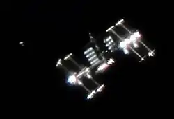 Mezinárodní kosmická stanice: „Obrázek ukazuje nejen ISS s velmi zvláštním úhlem osvětlení, ale také ukazuje aktivitu kolem ISS, což je častý případ. Je vidět japonská nákladní loď HTV-1 krátce před dokovací stanicí a jen pár set metrů pod ISS.“