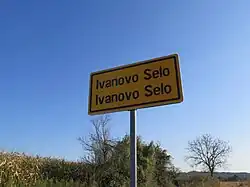 Dvojjazyčná tabule na příjezdu do Ivanova Sela
