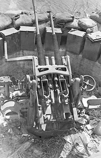 25mm kanón v dvojhlavňovém uspořádání ukořistěný Američany na Guamu v roce 1944. Zásobníky jsou odstraněny, ale jeden je položen na bedně s municí na pravé straně.