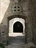 Kříž nad někdejším vchodem do kostela