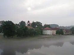 Část levobřežní zástavby obce s kostelem z mostu přes Vltavu