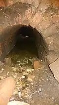 Pohled do vyzděné kanalizační stoky plné fekálií
