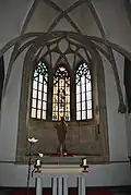 Presbytář s přiznaným kamenným zdivem a krouženou klenbou