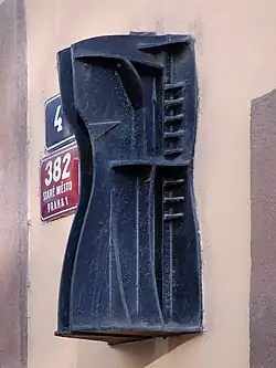 Šatičky (70. léta), litina, domovní znamení Na Můstku 4, Praha