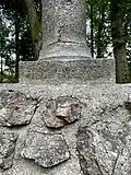 Nápis na soklu pamětního sloupu udává datum přemístění 1932