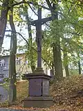 Kovový kříž před mateřskou školkou (dříve vrchnostenský úřad – v pozadí), Svitavy-Lány
