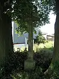Kamenný kříž u zemědělského areálu.