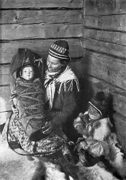 Černobílá fotografie ženy držící dítě v zavinovačce