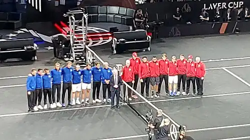 Zahajovací ceremoniál, modří Evropané a červení hráči zbytku světa; uprostřed Rod Laver
