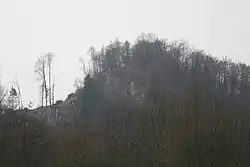 Pohled od Skalního mlýna na vrch s hradem Lečenec