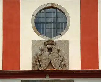 Detailní pohled na průčelí kostela s erbem a rozetou