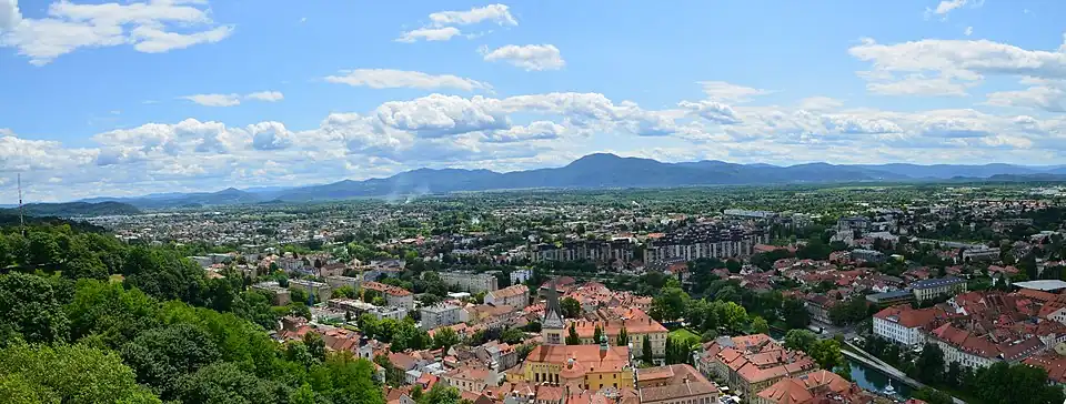 Pohled na jih z Lublaňského hradu s lublaňskými bažinami v pozadí. Hustota budov je v dáli podstatně nižší kvůli nevhodným pozemků pro stavby.