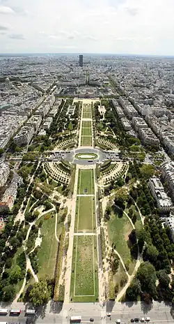 Pohled na park z Eiffelovy věže na pozadí s mrakodrapem Tour Montparnasse