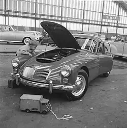 Maarten[kdo?] opustil svůj RAI náklaďák, prohlíží si MG coupé, 1961