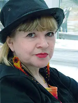 Žena v tmavém oblečení s tmavým kloboukem