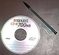 Obrázek kompaktního disku (tužka přiložena jako měřítko)
