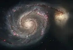 Na tomto snímku spirální galaxie je vidět, jak je jedno její rameno spojeno se sousední menší galaxií NGC 5195