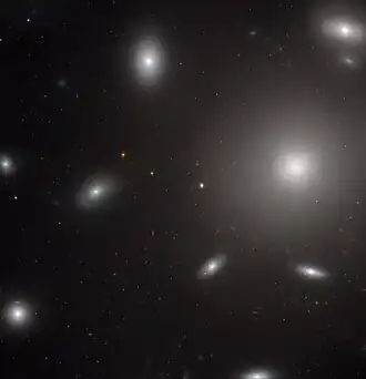 NGC 4874 vévodí tomuto snímku ve viditelném a blízkém infračerveném spektru, jak jej pořídila širokoúhlá přehlídková kamera z Hubbleova vesmírného dalekohledu.