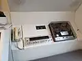 Interiér buňky – telefon, magnetofon, rádio, hodiny