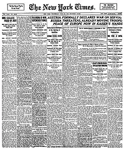 Černobílá fotografie titulní strany novin The New York Times z 29. července 1914. Hlavní titulek na stránce hlásá "AUSTRIA FORMALLY DECLARES WAR ON SERVIA; RUSSIA THREATENS, ALREADY MOVING TROOPS; PEACE OF EUROPE NOW IN KAISER'S HANDS". Stránka je plná textu rozděleného do sloupců s různými články a zprávami, které poskytují informace o tehdejších světových událostech.