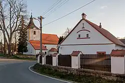 Dům s kostelem sv. Kateřiny v obci (2019)