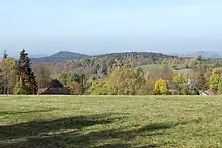 Pohled na kopce Hejnické pahorkatiny od osady Přebytek u Ludvíkova pod Smrkem, vlevo v pozadí je vrch Chlum