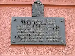 Pamětní deska na vnějším plášti objektu na adrese: V Háji 1243/35, 170 00 Praha 7 - Holešovice[18]