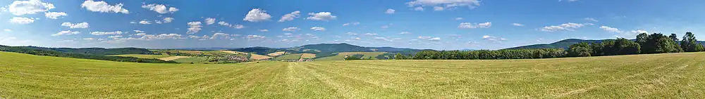 Panoramatický pohled na Velký Lopeník (uprostřed) od západu, v popředí obec Strání