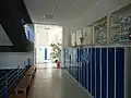 Chodba v přízemí s úschovnými skříňkami a výstavkou trofejí ze sportovních soutěží