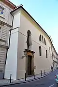 Vstup do kostela a prostá fasáda v Bartolomějské ulici