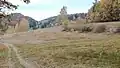 Na obzoru hraniční údolí mezi Prasečím hřbetem Hronovské kotliny (Świni Grzbiet/Schweinsrücken) vlevo a vrchem Miechy vpravo (517 m n. m.) v Levínské vrchovině (Horní Chudoba/Kudowa Górna)