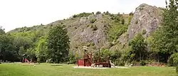 Skalní amfiteátr nad bývalým klukovickým koupalištěm v Prokopském údolí (odsud vstupy do Korálových jeskyní nejsou viditelné)