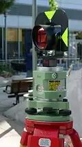 Samostatný laserový dostřeďovač Leica SNLL121 s nasazeným odrazným hranolem pro světelný dálkoměr.