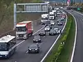 Objíždění nehody odstavným pruhem na dálnici D5 u Rudné