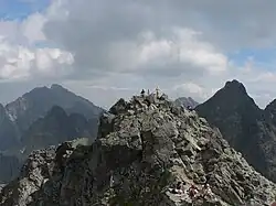 Pohled na nejvyšší skalnaté hřebeny, uprostřed vrchol s turisty