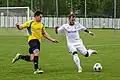 Hráč FK Kozlovice (ve žlutém) bojuje o míč s dětmarovickým Erikem Puchelem (2019)