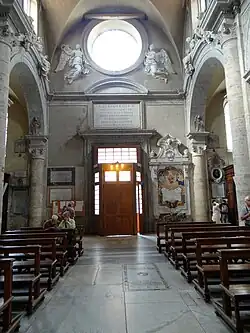 Stěna s vchodem a dedikací papeže Alexandra VII., Ercole Ferrata (1655-58)