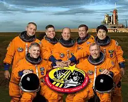 Přední řada zleva: Gregory Johnson, Dominic Gorie. Zadní řada zleva: Richard Linnehan, Robert Behnken, Garrett Reisman, Michael Foreman a Takao Doi