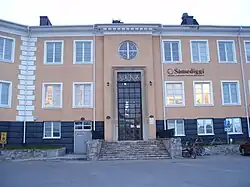 Průčelí dvoupatrové budovy s centrálním schodištěm a vchodem