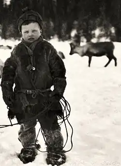 Černobílá zimní fotografie hocha v kožešinových botech