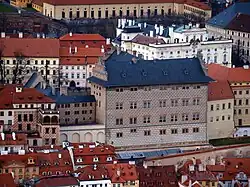 Schwarzenberský palác v hradčanské historické zástavbě, za ním světlý Arcibiskupský palác a zcela v pozadí Jízdárna Pražského hradu