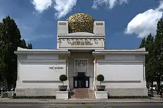 Budova Pavilonu Secese ve Vídni s charakteristickou zlatou kopulí tvořenou listy vavřínu a monumentálním vstupem