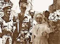 Jeptiška drží sadu zubních náhrad pacienta, který je upustil z okna katolické nemocnice přes demarkační linii na jordánské území. Jeptiška směla překročit hranice až po dlouhém vyjednávání. Autorova první mezinárodně publikovaná fotografie, 22. května 1956.