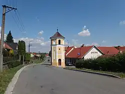 Hlavní ulice s památkově chráněnou zvonicí