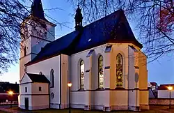 Kostel Nanebevzetí Panny Marie v pohledu od budovy děkanství; kostel městského typu, původně farní, v roce 1655 povýšen spolu s farou na děkanský, podle historických výzkumů byla výstavba realizována v gotickém stylu staviteli majících blízko k parléřovské huti